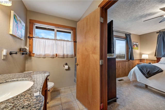 bathroom with ceiling fan, tile patterned floors, a textured ceiling, toilet, and vanity