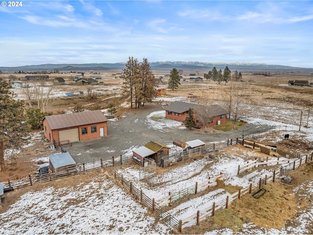 snowy aerial view with a mountain view and a rural view