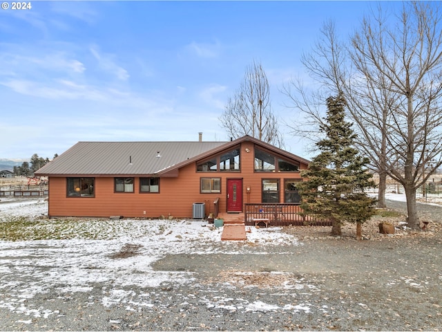 snow covered property with central AC