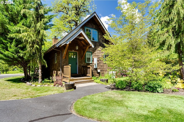 cabin featuring a front lawn