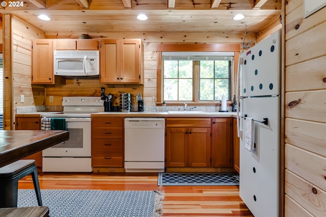 kitchen with white appliances, sink, beam ceiling, light hardwood / wood-style flooring, and wooden ceiling