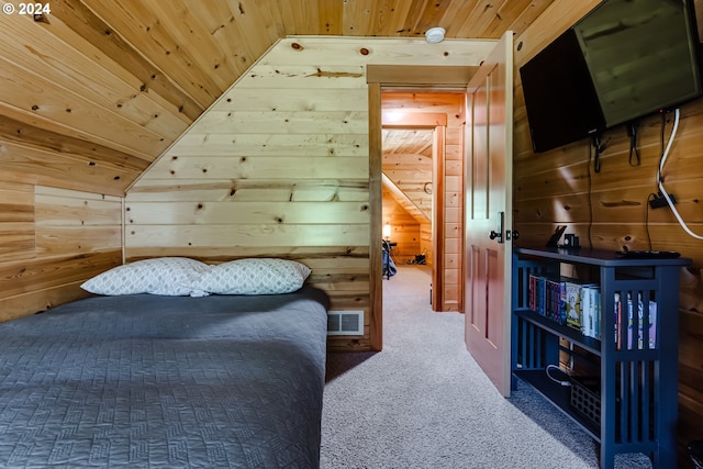 bedroom with carpet, wood walls, and vaulted ceiling