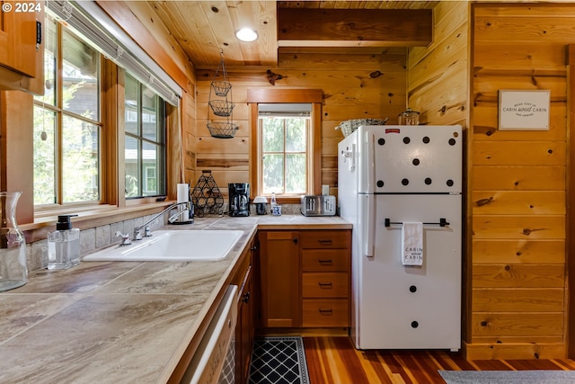 kitchen with sink, white fridge, a healthy amount of sunlight, and hardwood / wood-style flooring