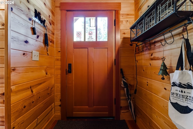 doorway to outside with wood walls