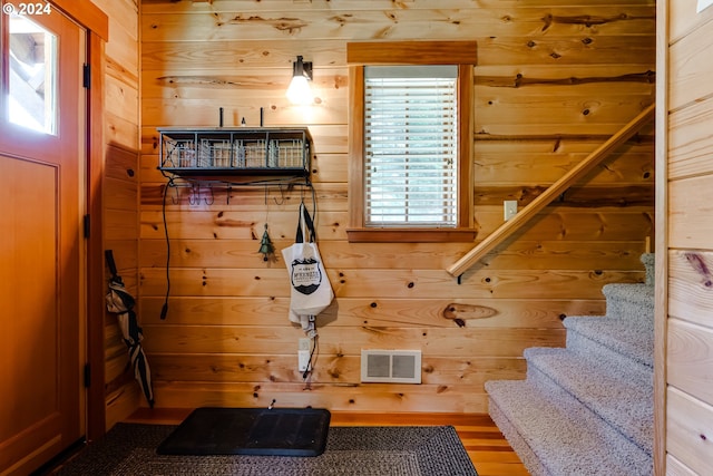 interior space with wood walls and hardwood / wood-style flooring