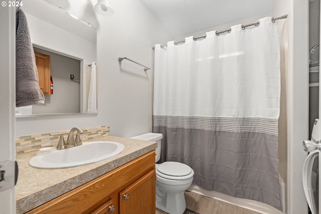 bathroom with vanity, toilet, curtained shower, and decorative backsplash