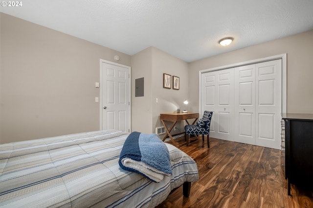 bedroom with a closet, hardwood / wood-style floors, and electric panel