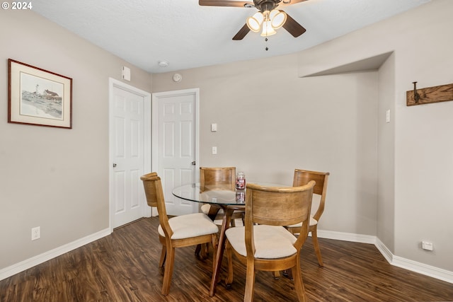 dining space featuring ceiling fan and dark wood-type flooring