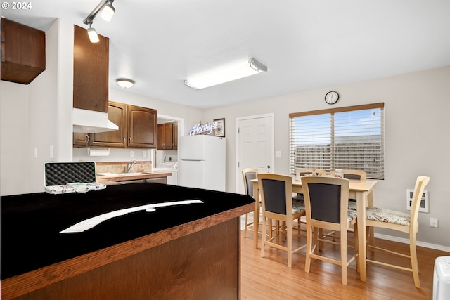 kitchen with sink, light hardwood / wood-style flooring, and white fridge