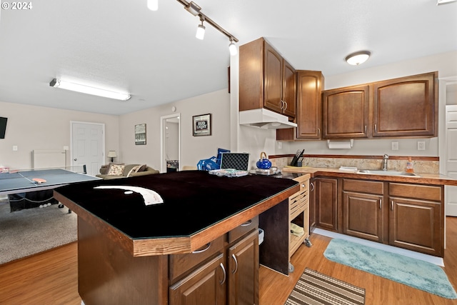 kitchen featuring sink, light hardwood / wood-style flooring, and a kitchen island