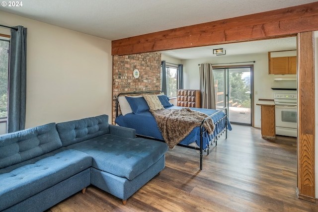 bedroom with access to outside and wood finished floors