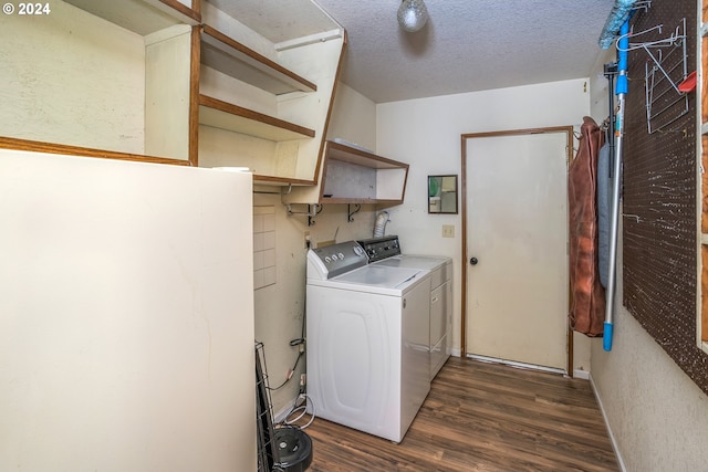 laundry room with washing machine and dryer, laundry area, dark wood finished floors, and a textured ceiling