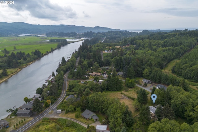 drone / aerial view with a wooded view and a water and mountain view