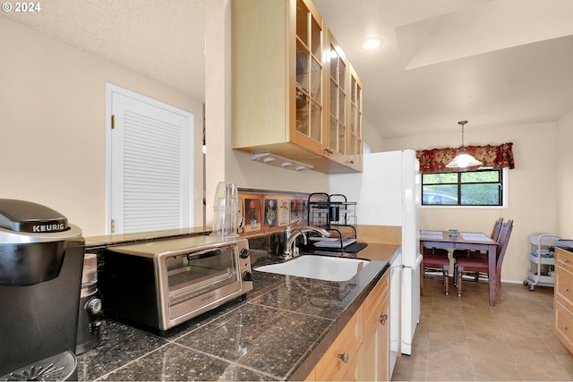 kitchen with tile patterned floors, sink, pendant lighting, light brown cabinets, and lofted ceiling