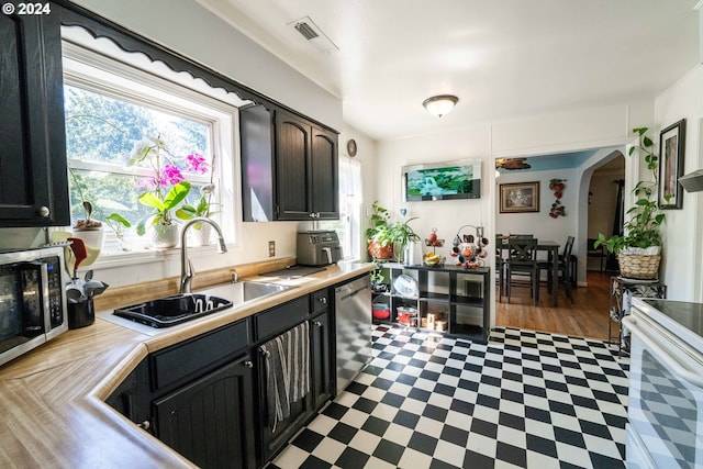 kitchen featuring sink, appliances with stainless steel finishes, dark hardwood / wood-style floors, and dark brown cabinets