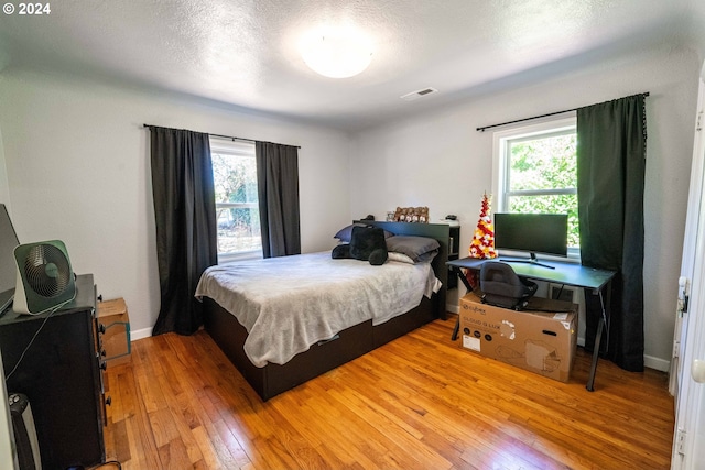 bedroom featuring light wood-type flooring and a textured ceiling