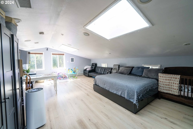 bedroom with lofted ceiling and light wood-type flooring