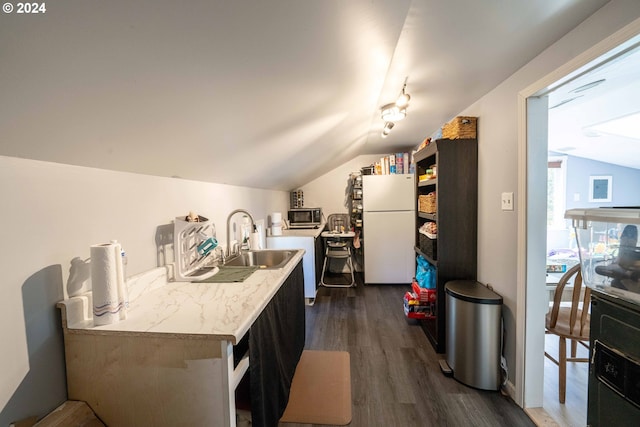 kitchen with lofted ceiling, dark hardwood / wood-style floors, track lighting, white refrigerator, and sink