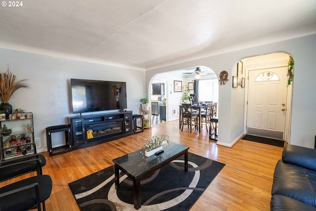 living room featuring light wood-type flooring and ceiling fan