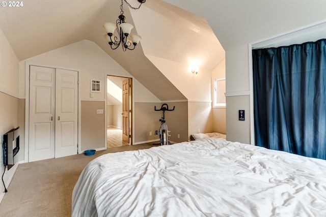 carpeted bedroom featuring an inviting chandelier, vaulted ceiling, and a closet