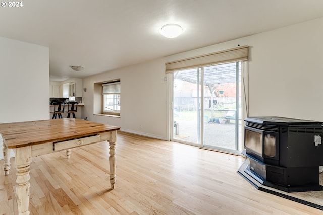 dining space with a wood stove and light hardwood / wood-style floors