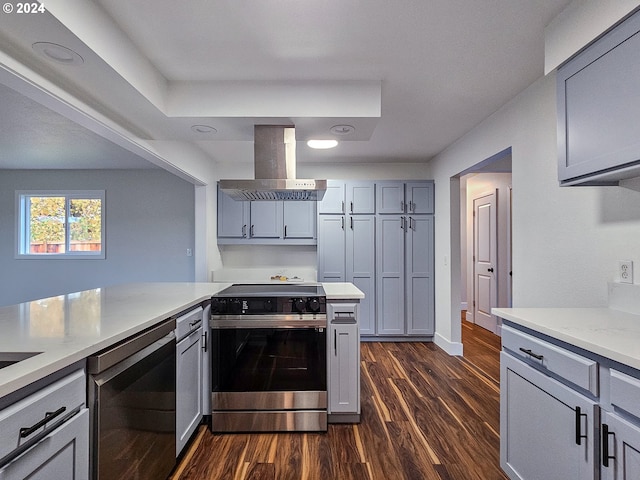 kitchen featuring gray cabinets, island range hood, dark wood-type flooring, and stainless steel range