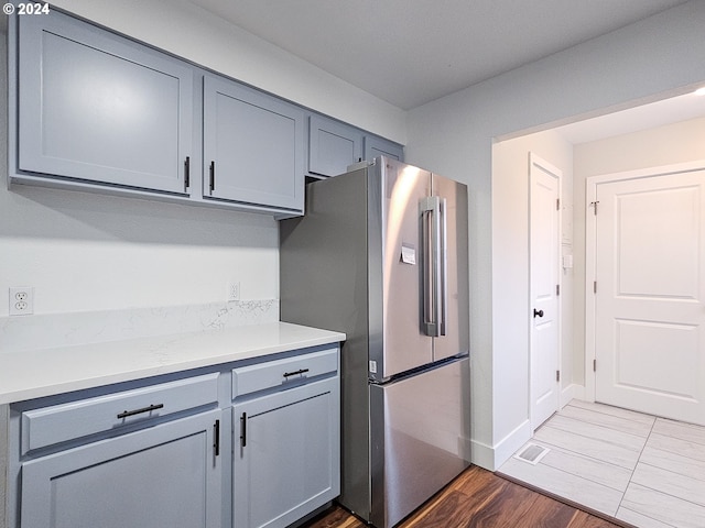 kitchen with stainless steel fridge and dark hardwood / wood-style floors