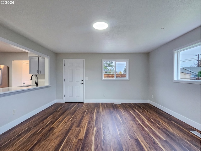 entrance foyer with a textured ceiling and dark hardwood / wood-style floors