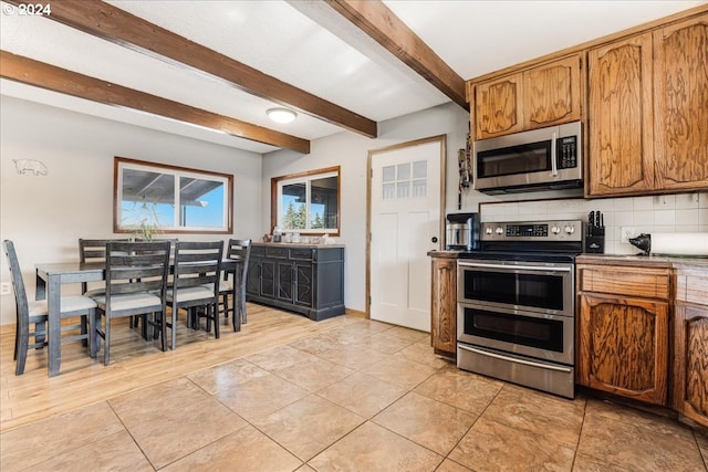 kitchen featuring light tile patterned floors, stainless steel appliances, decorative backsplash, and beamed ceiling