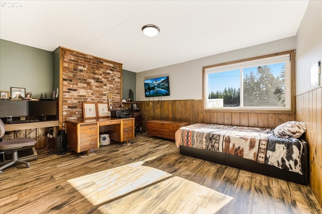 bedroom with wood walls and wood-type flooring