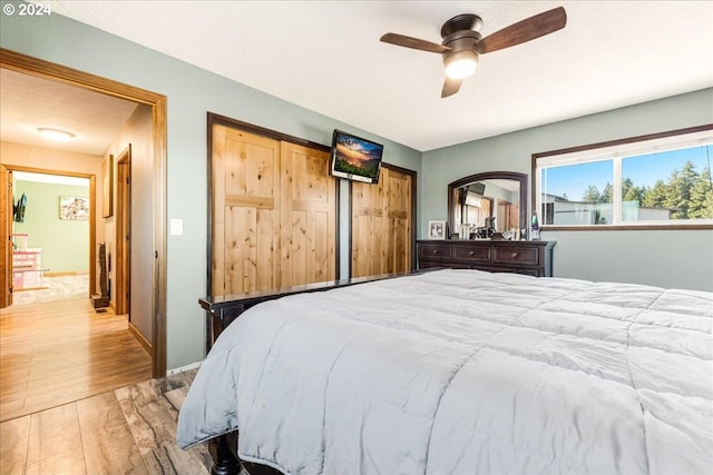 bedroom with ceiling fan, a textured ceiling, and light wood-type flooring