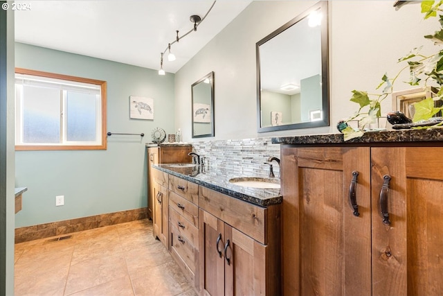 bathroom with vanity, tile patterned floors, and backsplash