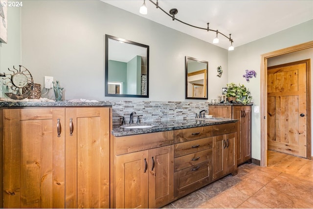 bathroom featuring vanity, rail lighting, backsplash, and tile patterned flooring