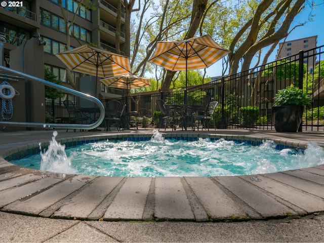 view of pool featuring fence and a hot tub