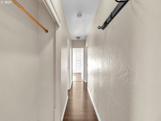 corridor with dark hardwood / wood-style flooring