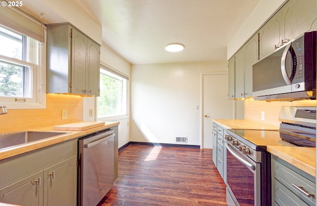 6312 SW Lesser Way, Portland, OR 97219 - kitchen featuring stainless steel appliances, dark wood finished floors, backsplash, and light countertops
