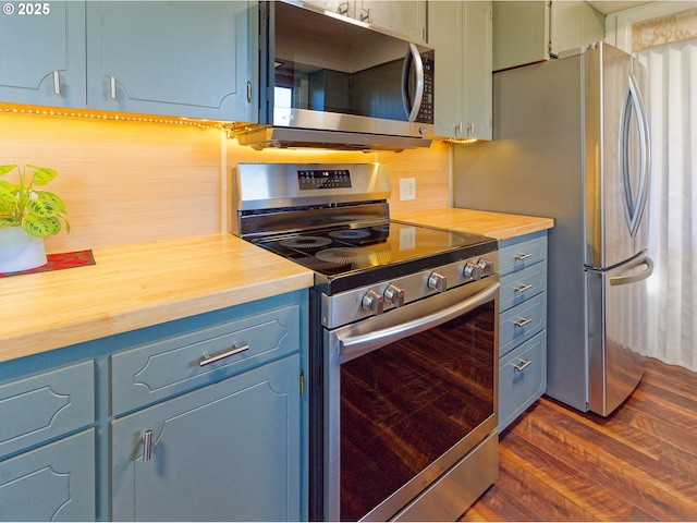 6312 SW Lesser Way, Portland, OR 97219 - kitchen with stainless steel appliances, dark wood finished floors, and wooden counters