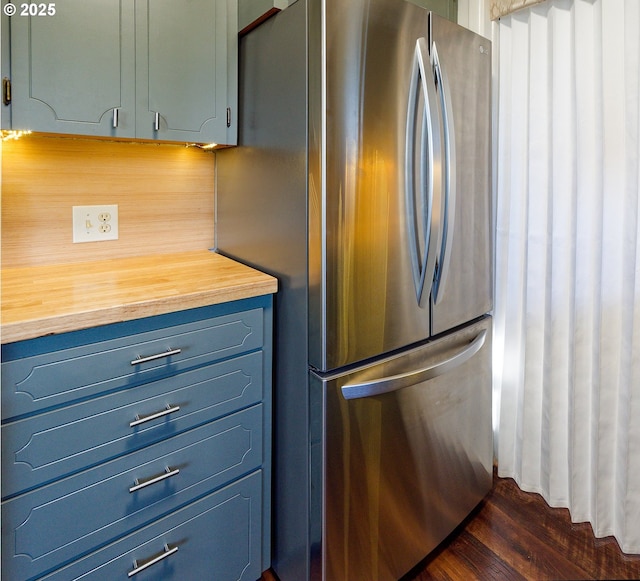 6312 SW Lesser Way, Portland, OR 97219 - kitchen featuring freestanding refrigerator, wooden counters, blue cabinets, dark wood-style flooring, and decorative backsplash