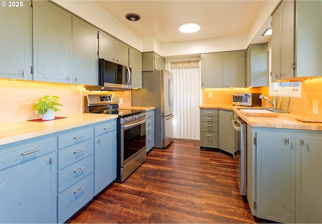 6312 SW Lesser Way, Portland, OR 97219 - kitchen featuring stainless steel appliances, dark wood finished floors, light countertops, backsplash, and a sink