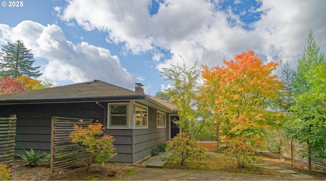 6312 SW Lesser Way, Portland, OR 97219 - view of home's exterior featuring a chimney, roof with shingles, and fence