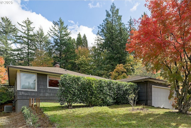 6312 SW Lesser Way, Portland, OR 97219 - view of front of home featuring a garage, a front lawn, central AC, and a chimney