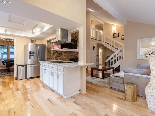 kitchen with light wood-type flooring, island range hood, stainless steel fridge with ice dispenser, and white cabinets