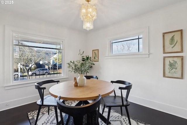 dining area with wood-type flooring and an inviting chandelier