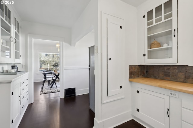 kitchen featuring white cabinets, backsplash, butcher block countertops, and dark wood-type flooring