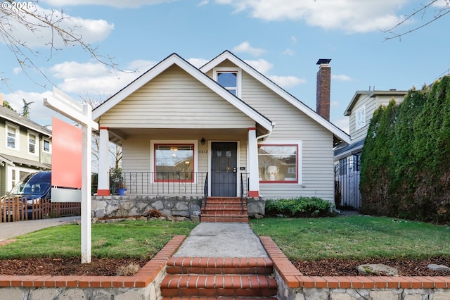 bungalow-style house featuring a porch and a front lawn