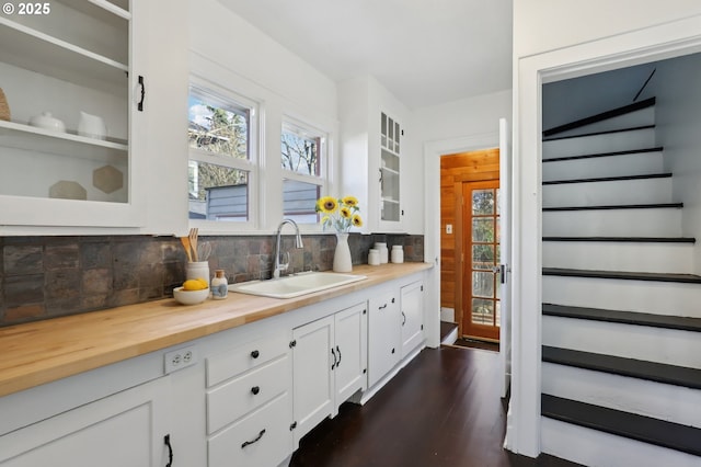 bar with wooden counters, white cabinets, sink, decorative backsplash, and dark hardwood / wood-style floors