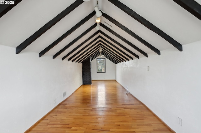 interior space with vaulted ceiling with beams and light hardwood / wood-style flooring