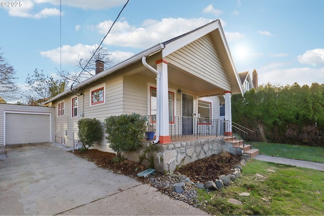 view of front of home featuring a garage, covered porch, an outdoor structure, and a front yard