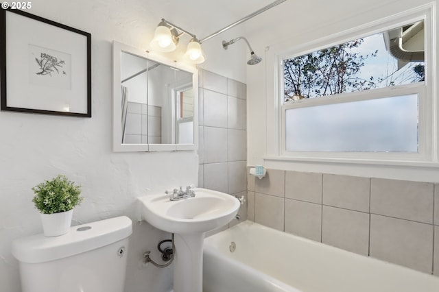 bathroom featuring a healthy amount of sunlight, toilet, and bathtub / shower combination