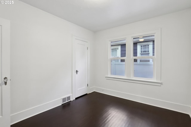 empty room with dark hardwood / wood-style flooring